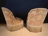 pair of antique chairs with fringe trims on them on a table