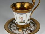 an antique cup and saucer with a gold rim on a saucer