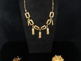 une vitrine contenant un collier, des boucles d'oreilles et d'autres bijoux
