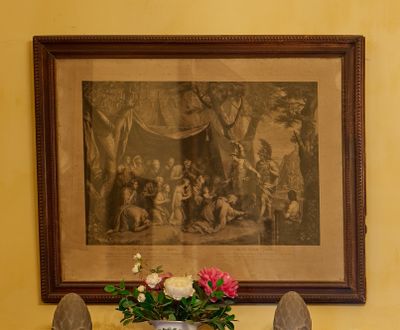 un vase de fleurs posé sur une table devant un tableau