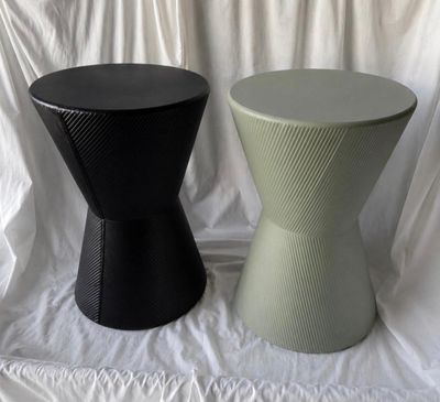 two black and green stools sitting on a white sheet