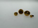 two pairs of gold colored studs on a white surface