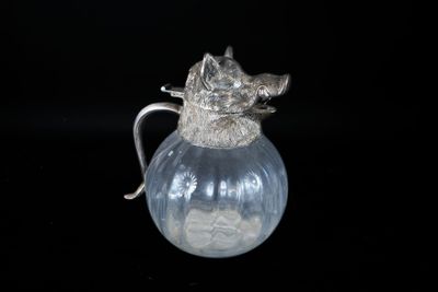 un pichet en verre avec une anse en argent sur fond noir