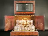 bottles and glasses in a wooden case with a mirror on a table