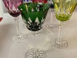 several different colored wine glasses are lined up on a table