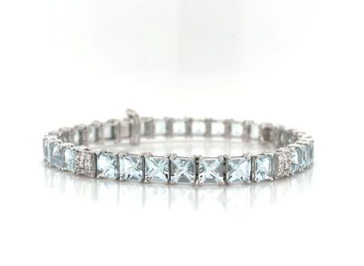 a close up of a diamond bracelet on a white surface