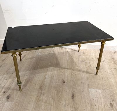 une photo d'une table basse noire et dorée posée sur un parquet