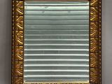 an image of a gold framed mirror on a wall in a room