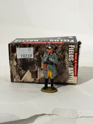 figurine représentant un homme en uniforme debout devant une boîte