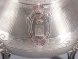 a large silver bowl with a handle on a stand