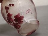 a hand that is holding a glass vase with flowers on it