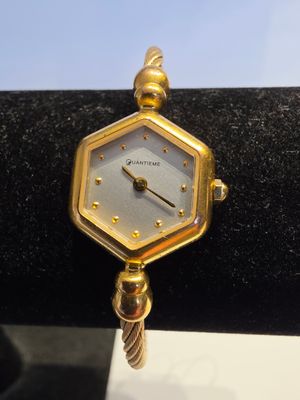un gros plan d'une montre en or posée sur une bague noire