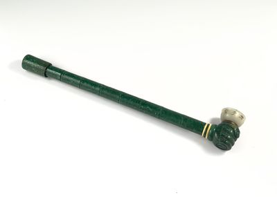 une image représentant un tuyau vert muni d'une poignée métallique, posé sur une surface blanche