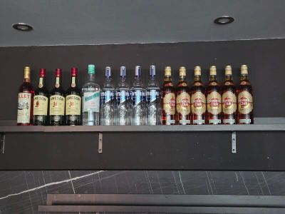 Des bouteilles d'alcool sont alignées sur une étagère dans un bar