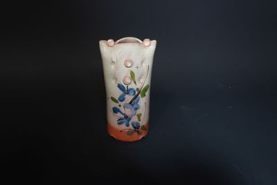 a small vase with a flower design on it