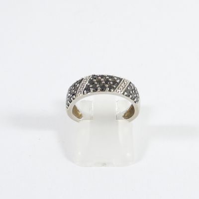 an image of a ring with black and white diamonds on a white surface