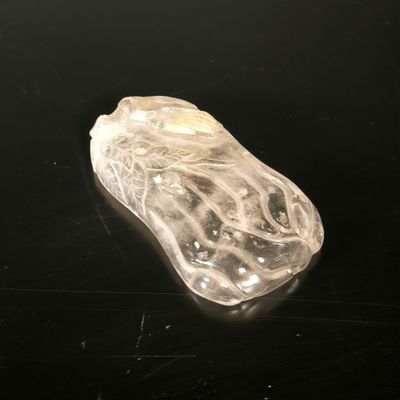 un objet en verre transparent posé sur une surface noire
