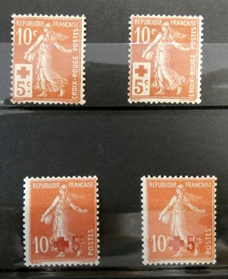 four stamps of different sizes and colors on a black surface