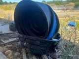 a large black barrel sitting on the side of the road