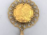 a close up of a gold coin with a bell on it
