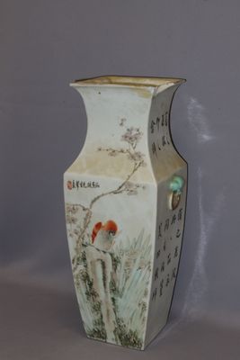 a vase with a bird on it sitting on a table