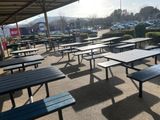 a lot of tables and benches in a parking lot