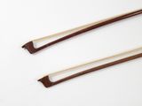 two wooden chopsticks sitting next to each other on a white surface