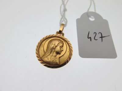 un gros plan sur un collier en or orné d'une image représentant une femme