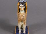 an image of a figurine of a woman with a bird on her head
