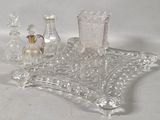 a glass tray with a candle holder and other items on it