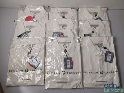 Six t-shirts blancs sont emballés dans des sacs en plastique sur une table