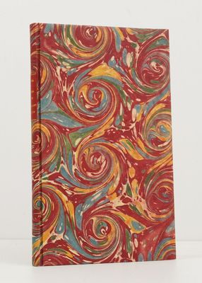 a red notebook with colorful swirls on it sitting on a white surface
