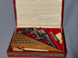 une mallette rouge contenant un pistolet, une règle et d'autres objets
