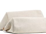 the large beige bag is sitting on a white surface