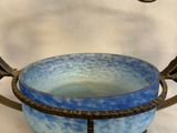 a blue bowl sitting on top of a metal stand