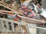 a wheelbarrow full of assorted items in a garage