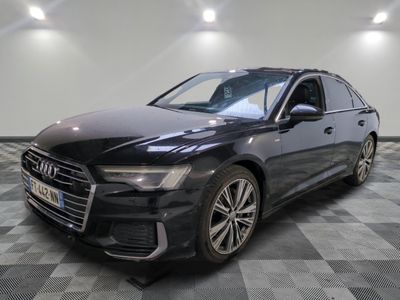 une Audi noire garée sur un sol en carrelage à damier dans un garage