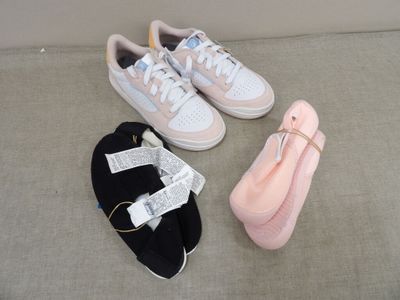 three pairs of shoes and a pink bag on the floor