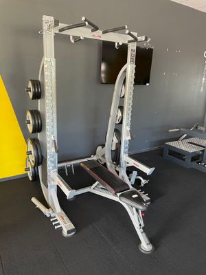 une salle de sport équipée d'une barre à disques et d'une machine de musculation