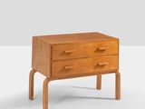an image of a small wooden chest of drawers on a white surface