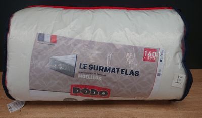 L'oreiller est blanc et orné de bordures rouges.