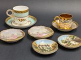 five cups and saucers with pictures on them on a table
