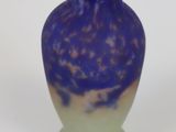 a purple vase sitting on a white surface with a white background