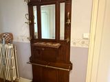 a wooden cabinet with a mirror and a radiator in the corner