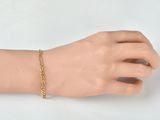 a mannequin hand with a gold chain bracelet on it