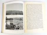 an open book with a picture of a group of people in a field
