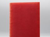 un livre rouge posé sur une surface blanche