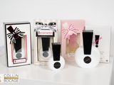 trois flacons de parfum et une boîte posés sur une table blanche