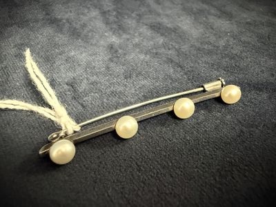 a close up of a hair pin with pearls on it