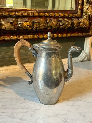 a silver coffee pot sitting on a marble counter